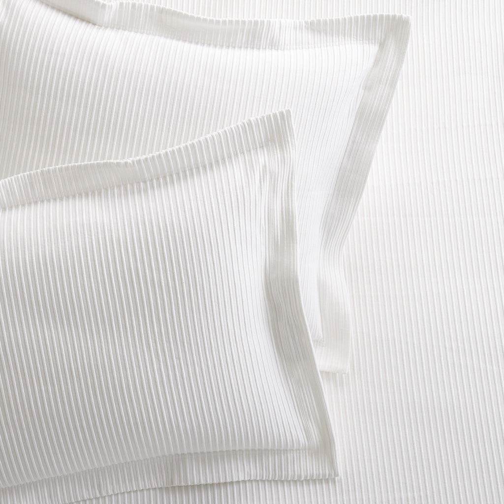 Set of 2 white ribbed cotton Matelassé pillow shams with tailored edges.
