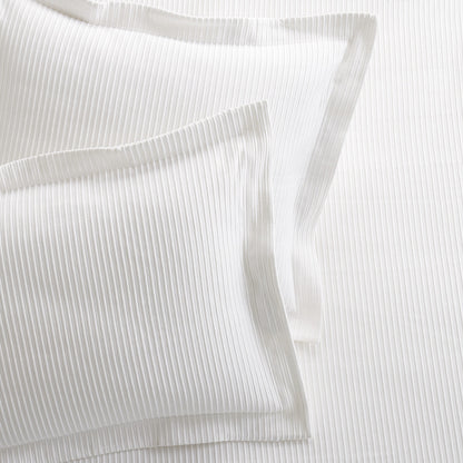 Set of 2 white ribbed cotton Matelassé pillow shams with tailored edges.