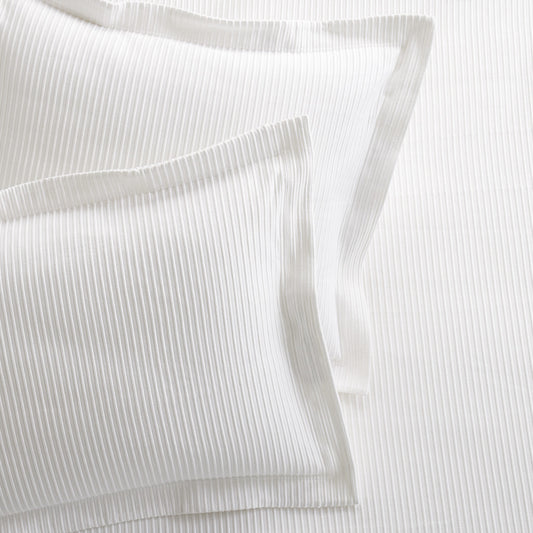 Set of 2 white ribbed cotton Matelassé pillow shams with tailored edges.