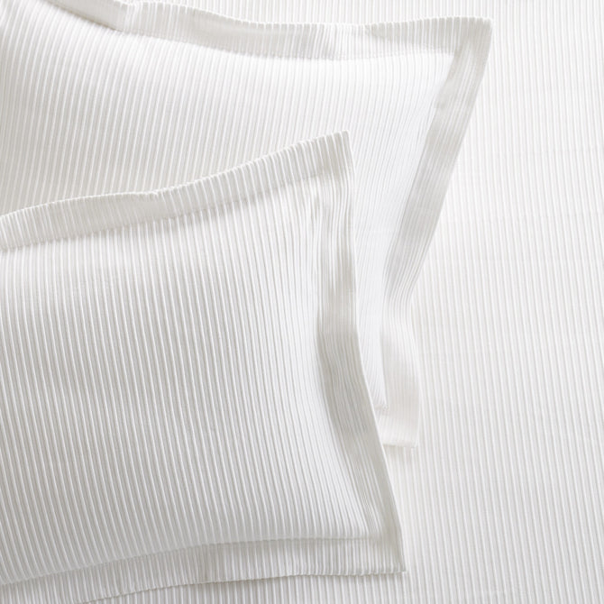 Set of 2 white ribbed cotton Matelassé pillow shams with tailored edges.