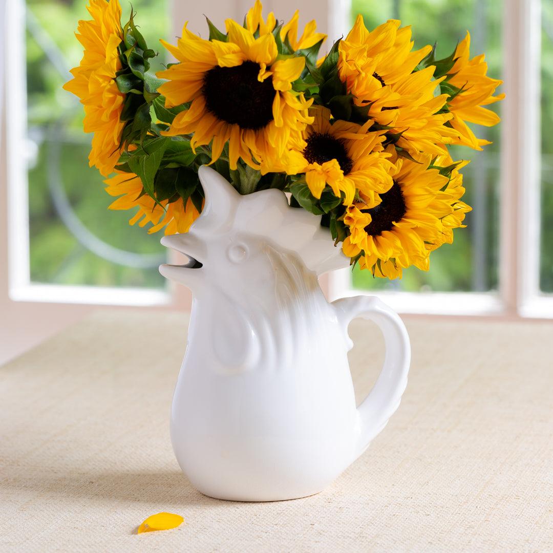 White ceramic rooster pitcher holding yellow sunflowers, 10"H.