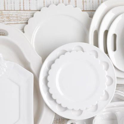 White ceramic scalloped salad plate on a stack of whiteware, 8.75" diameter.