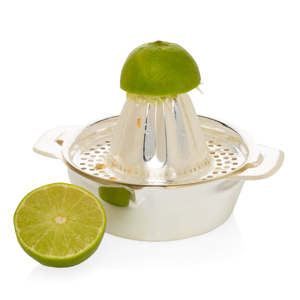 HG Silverplate Lemon Juicer, oversized, with a lime half on the reamer and another lime half beside it.