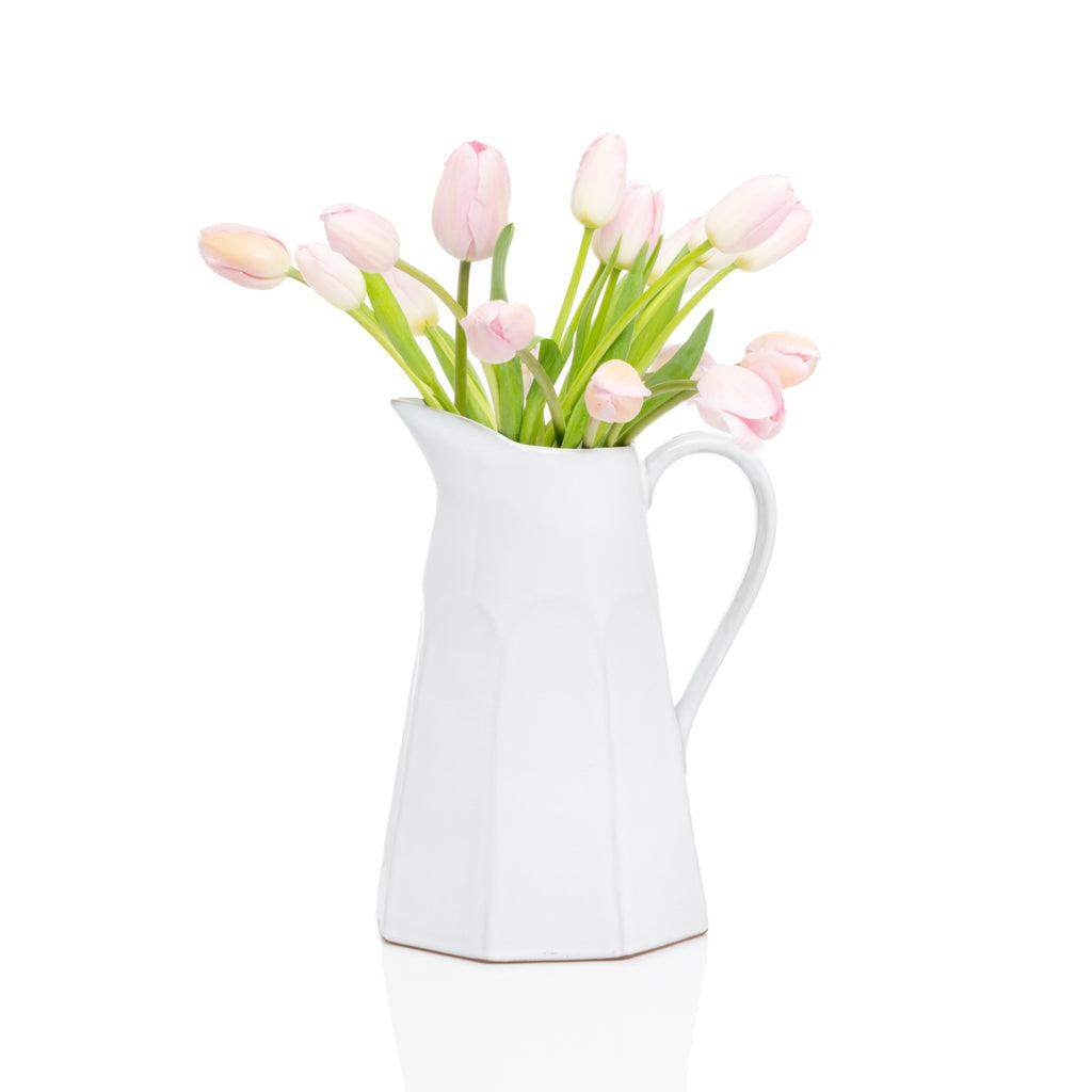 Stone grey terracotta pitcher with subtle vertical ridges, filled with pink tulips.