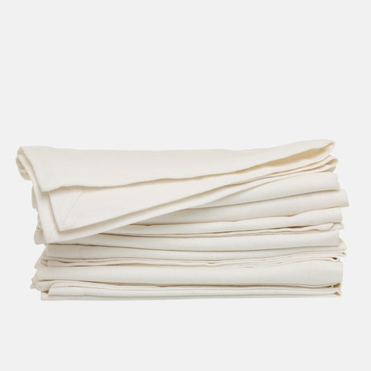 Stack of folded stonewashed white denim napkins, 20" square, with single needle stitch.