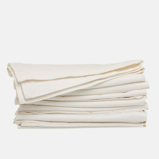 Stack of folded stonewashed white denim napkins, 20" square, with single needle stitch.