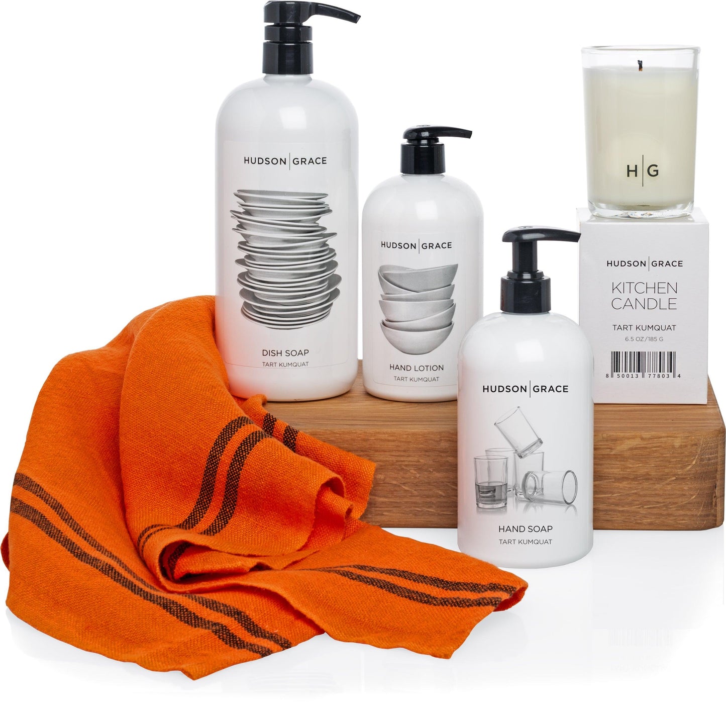 Hudson Grace Tart Kumquat Dish Soap, Hand Lotion, Hand Soap, and Kitchen Candle with an orange striped towel.