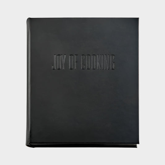 Black leather "Joy of Cooking" cookbook with blind embossed title.