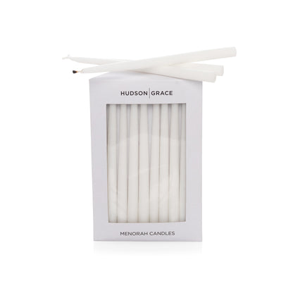 Hudson Grace white paraffin Menorah candles, delicate elongated tapers, in a white box with window.