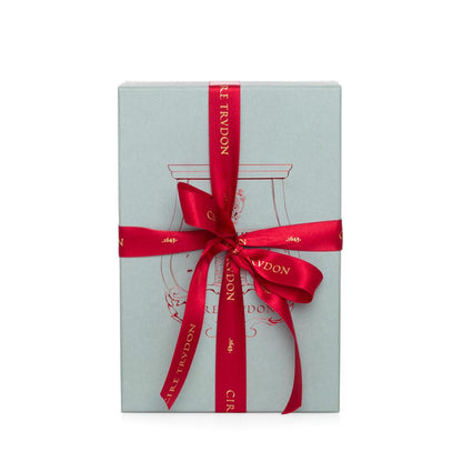 Light blue gift box with red "Cire Trudon" ribbon tied in a bow.