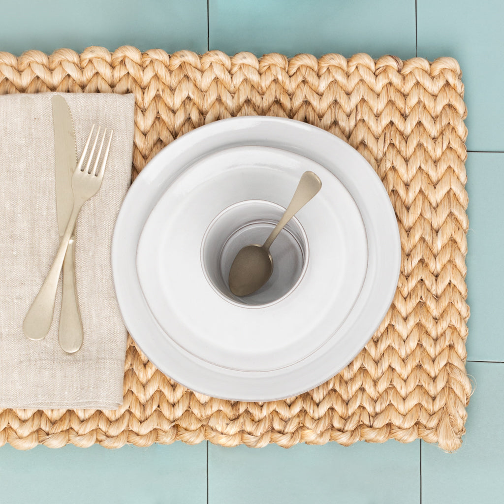 Vintage Champagne 5-piece flatware set: knife, fork, and spoon on a woven placemat with white plates.