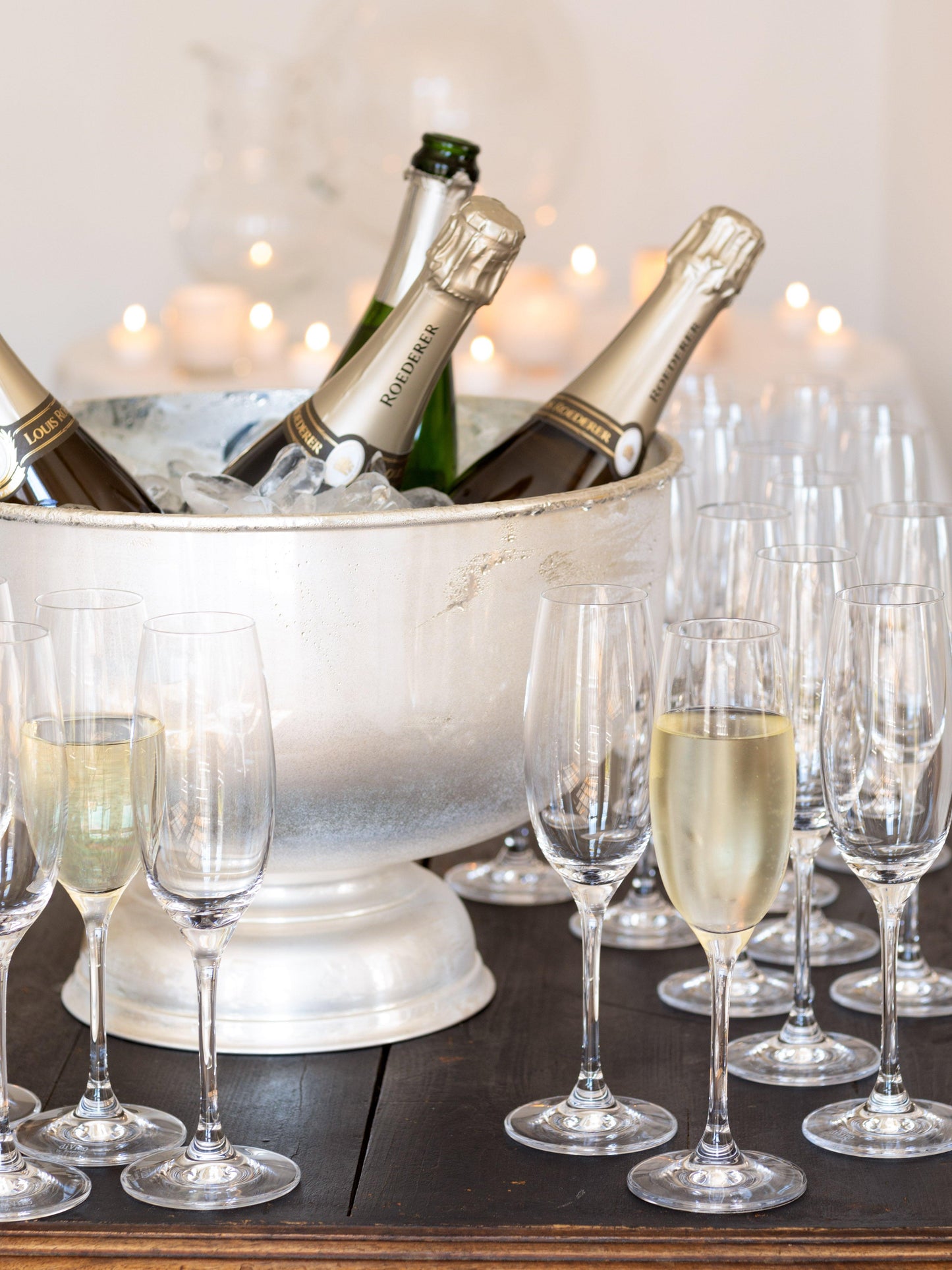 Vintage silverplate footed grand punch bowl, 18", holding champagne bottles on ice with flutes.