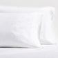 Set of two white washed-linen pillowcases with double-needle stitch detailing and side opening.