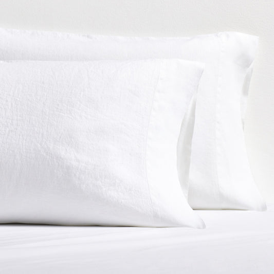 Set of two white washed-linen pillowcases with double-needle stitch detailing and side opening.