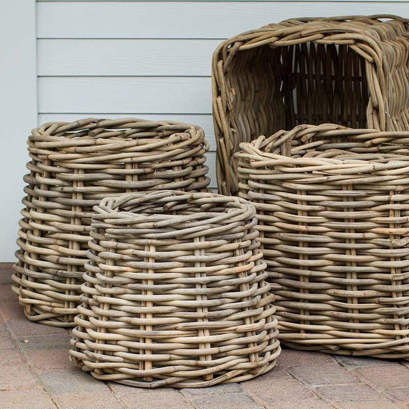 Three woven sandblasted rattan conic baskets in varying sizes, light brown, rustic style.